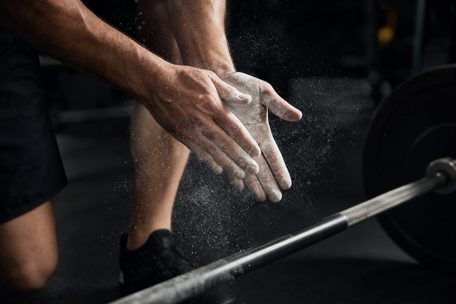 Chalked hands above a barbell